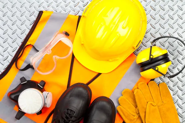 Hombre sonriente equipado con casco, lentes y guantes muestra la importancia de portar un buen EPP en labores técnicas.