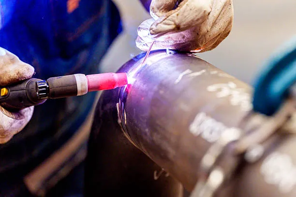 Trabajador ejecutando soldadura con equipo profesional, asegurando limpieza y cuidado de la máquina, representando la aplicación práctica del mantenimiento preventivo equipo de soldadura.