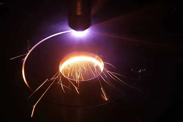 Máquina de oxicorte realizando un corte circular sobre una lámina gruesa de acero, generando un borde limpio y definido.