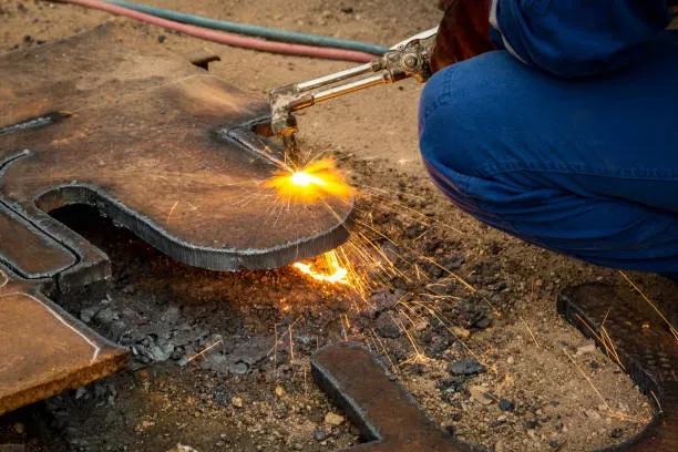 Tecnología de oxicorte aplicada en láminas gruesas de acero, ideal para procesos de fabricación industrial pesada.