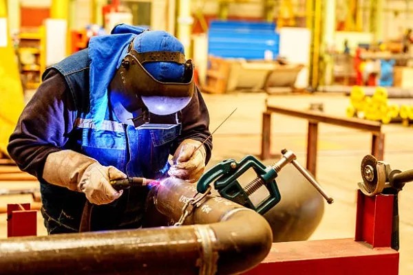 Hombre realizando soldadura TIG con control de arco y precisión en estructura metálica
